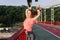 Slim woman playing with her hair during photoshoot at stadium. Sporty relaxed girl enjoying summer