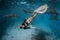 Slim woman snorkeling in a clear tropical water with nurse sharks in Maldives