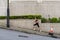 Slim young woman running uphill on sidewalk of city street. Female athlete training outside