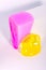 Slime, bright pink toy flows down of white box, against white background