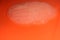 Slime on an orange background. Snot white on a bright background
