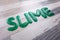 Slime text made from green slime on a wooden table