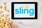 Sling on the screen of the tablet with popcorn box and Apple earphones on the background. Advertising or news content