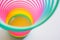 Slinky, plastic toy with colors of the rainbow, colorful children`s spring on a blue background.