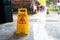 Slip warning sign on the sidewalk on a rainy day.