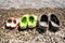 Slippers for the sea stand on a rocky beach opposite the sea hardly left to right from small to large