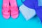 Slippers, swimsuit, towel on a blue pastel background. Rest, travel. Top view. Copy space. Flat lay.