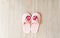 Slippers for women, children, soft, pink with a heart sticker on the wooden floor, close-up.