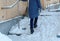 Slippery stairs. Unrecognizable woman in a blue down jacket walking up a snowy staircase.