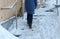 Slippery stairs. Unrecognizable woman in a blue down jacket walking up a snowy staircase.