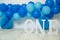 sliver, blue and white decoration for a 1st birthday cake smash studio photo shoot with balloons, paper decor, cake and