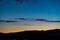 Sliver of a moon in the clouds over the mountains