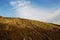 The slope of a clay hill against the backdrop of a beautiful blue sky. Lifeless soil. Sunny weather. Landscape