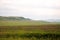 The slope of a high mountain at the beginning of the endless steppe flooded with sunlight