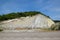 slope of the mountain with layers of sedimentary rocks. Vertically located sedimentary rocks on collapsing hillside