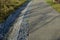 On the slope there are stairs in a row down. the staircase passes through a gabion wall to the asphalt pavement.