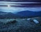 Slope with white boulders in mountains at night