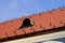 sloped beavertail clay tile roof. red brown color. copper plated dormer. forged steel snow guards