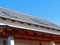 Sloped gray metal tile residential roof with skylights under blue sky