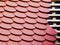 Sloped red clay tile roof detail with round edges of beaver tail tiles and wooden lattice