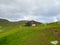 Slopes of hills rising above the GjÃ³gv village. Wooden bench in the background. Cloudy sky