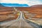 A sloping dirt road against a hill with vanishing point, Husavik, Iceland