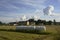 Sloping field and hay bales packed in white plastic