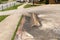 Sloping parking lot and drive leading to a sidewalk and well tended grass alongside a street