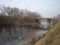 Sloping shore and water in the foreground, forest in background, autumn, Bridge West Bug