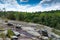 Sloping view from atop a large granite monadnock, Panola Mountain, Georgia USA, surrounding forest and blue sky