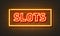 Slots neon sign on brick wall background.