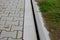 Slotted pipes drain rainwater and oil substances, drips from paved surfaces. concrete products at the curb interlocked paving tile