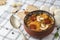 Slovak Christmas national cabbage soup in small black pot with sausage on the tablecloth background