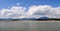 Slovakia lake with blue water and sand beach, white clouds on blue sky