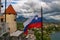 Slovenian national official flag waving on flagpole of Bled Castle, Slovenia