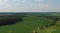 Slow aerial fly over of green crop fields with a blue sky