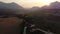 Slow aerial winding river with distant Canadian Rockies at sunset Crowsnest Pass