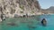 Slow Dolly Aerial in between rock fomations in Turquoise Blue Ocean Water on Greek Island Milos