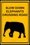 Slow Down Elephants Crossing Road sign