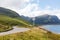 Slow-driving car on single wavy, serpentine road in North Coast 500, Scotland