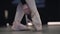 Slow-mo of graceful unrecognisable caucasian ballerina tying up pointes. Elegant female ballet dancer putting on ballet