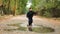 Slow motion: an active child in rubber boots runs merrily in a puddle in autumn after rain