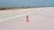 slow motion aerial footage of affectionate couple gently embracing on white salty coast of pink lake looks like desert.