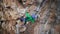 slow motion aerial view strong female rock climber climbs on overhanging cliff by hard route with rock tufas. woman