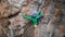 slow motion aerial view strong moman rock climber climbs on overhanging crag by hard challenging route. woman makes