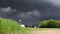 slow motion, approaching thunderstorm, stormy dark cloud, road with moving cars. Digital cinema composition background.