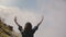 Slow motion back view of excited female tourist standing with arms wide open at epic Niagara Falls waterfall scenery.