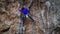 slow motion back view female rock climber climbs on overhanging limestone cliff by tough route