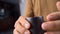 Slow motion of barista hand using a steel cup to collect coffee beans