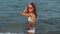Slow motion beautiful charming young womanin white bikini on sea background